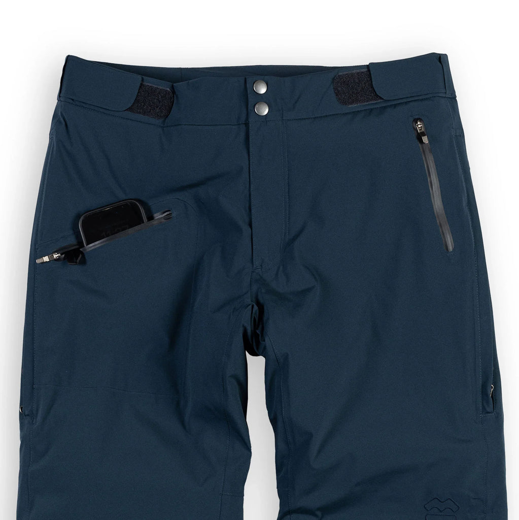 Men's Ezo Insulated Pant in Dark Navy, front view close up of the waist, and pocket with phone in it
